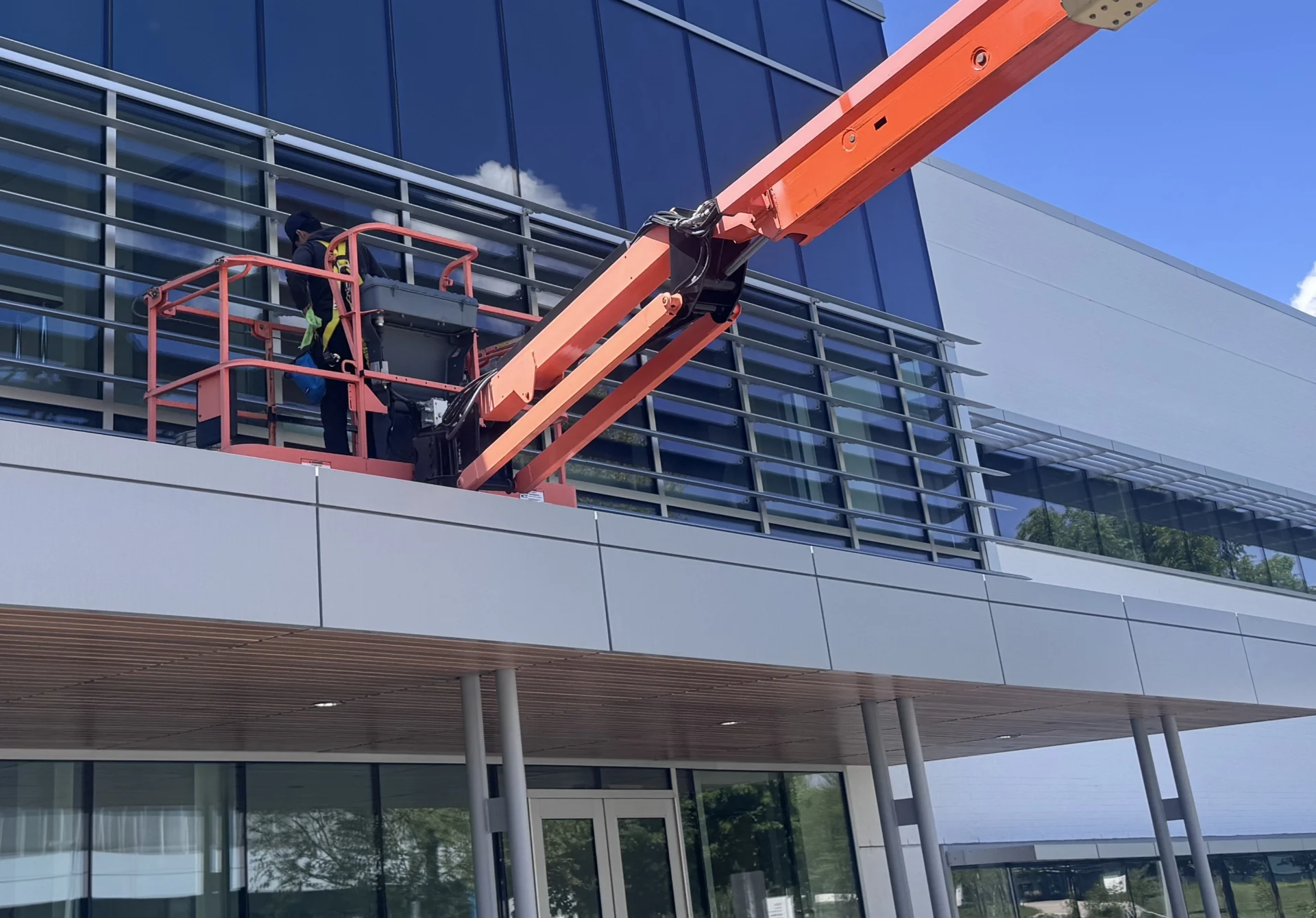 Walden technician on rope access cleaning a glass facade
